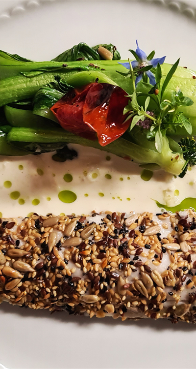 Filetto di branzino con semi tostati, pak choi alla piastra  e salsa al vino bianco